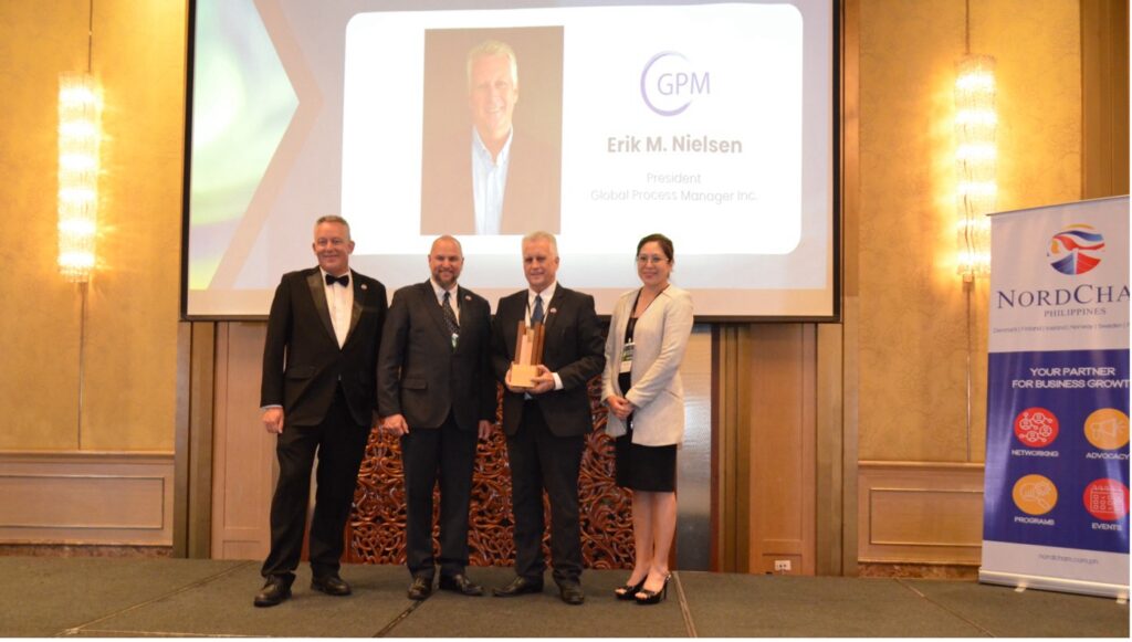 Erik Nielsen, NordCham Philippines Vice President and GPM President (standing 2nd from the right), accepts NordCham Philippines’ 2024 Legacy Award token on stage with (L-R): NordCham Philippines Executive Director Jesper Svenningsen, NordCham Philippines President Bo Lundqvist, and NordCham Philippines Corporate Secretary and BDO Unibank, Inc. First Vice President and Desk Head Marie Antoinette Mariano (Photo credit: Angel Ampil)